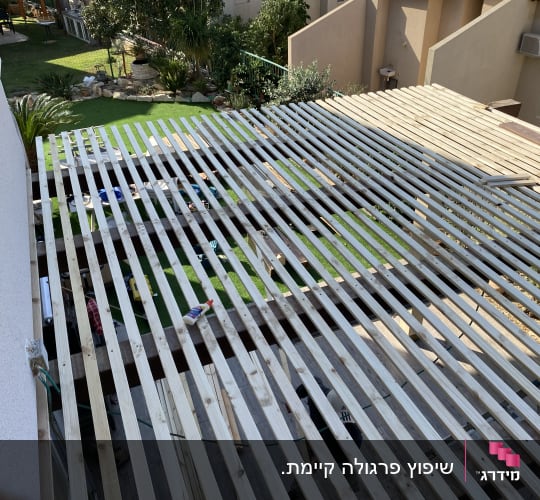 מבנה עץ בבנייה עם כלים וחומרים על הקרקע